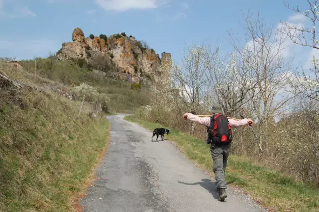 Randonneur face au rocher de Caylus sur la randonnée St-Affrique
